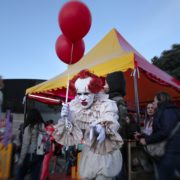clown holding two red balloons