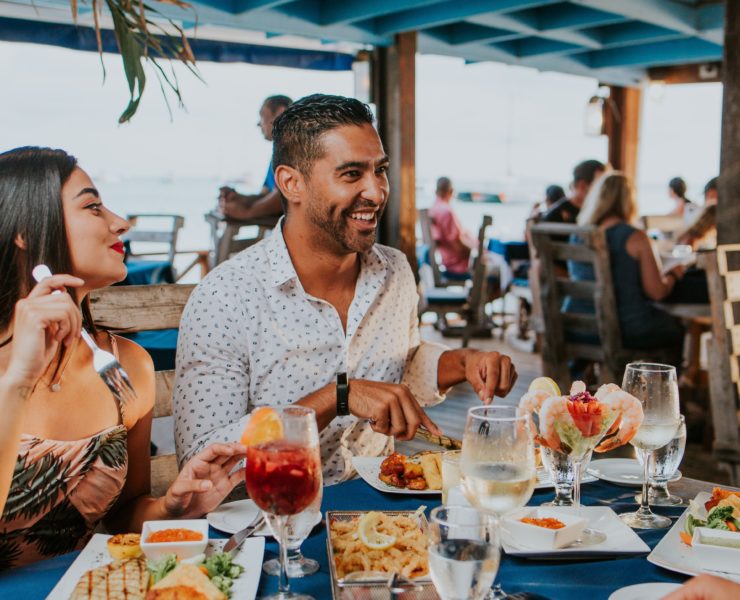 man and woman sitting on chair in front of table with food on top